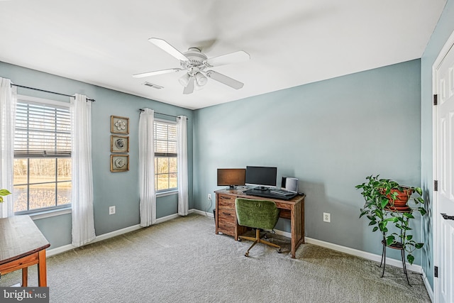 carpeted home office with ceiling fan and a healthy amount of sunlight