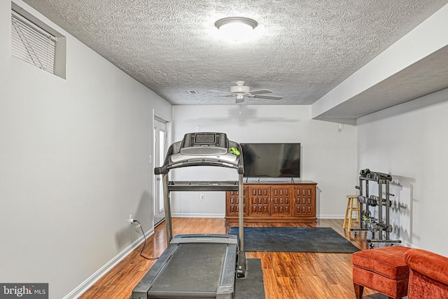 workout room with hardwood / wood-style flooring, a textured ceiling, and ceiling fan