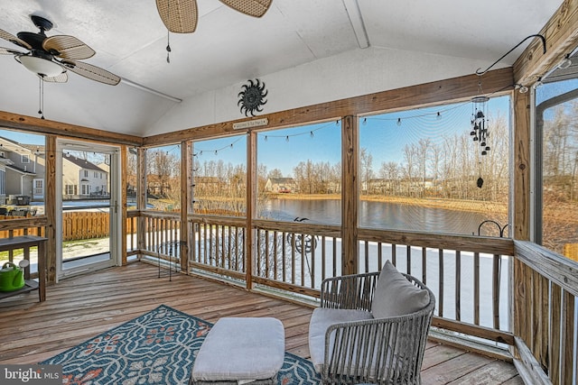 sunroom / solarium with lofted ceiling, ceiling fan, and a water view