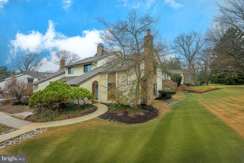 view of side of home with a yard