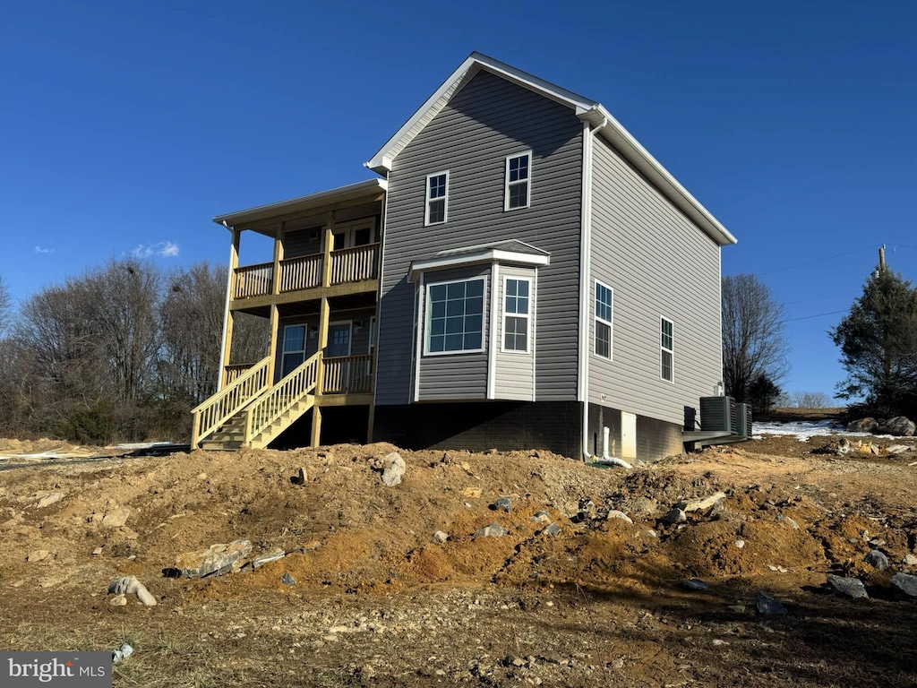 view of front of home featuring a balcony and central air condition unit