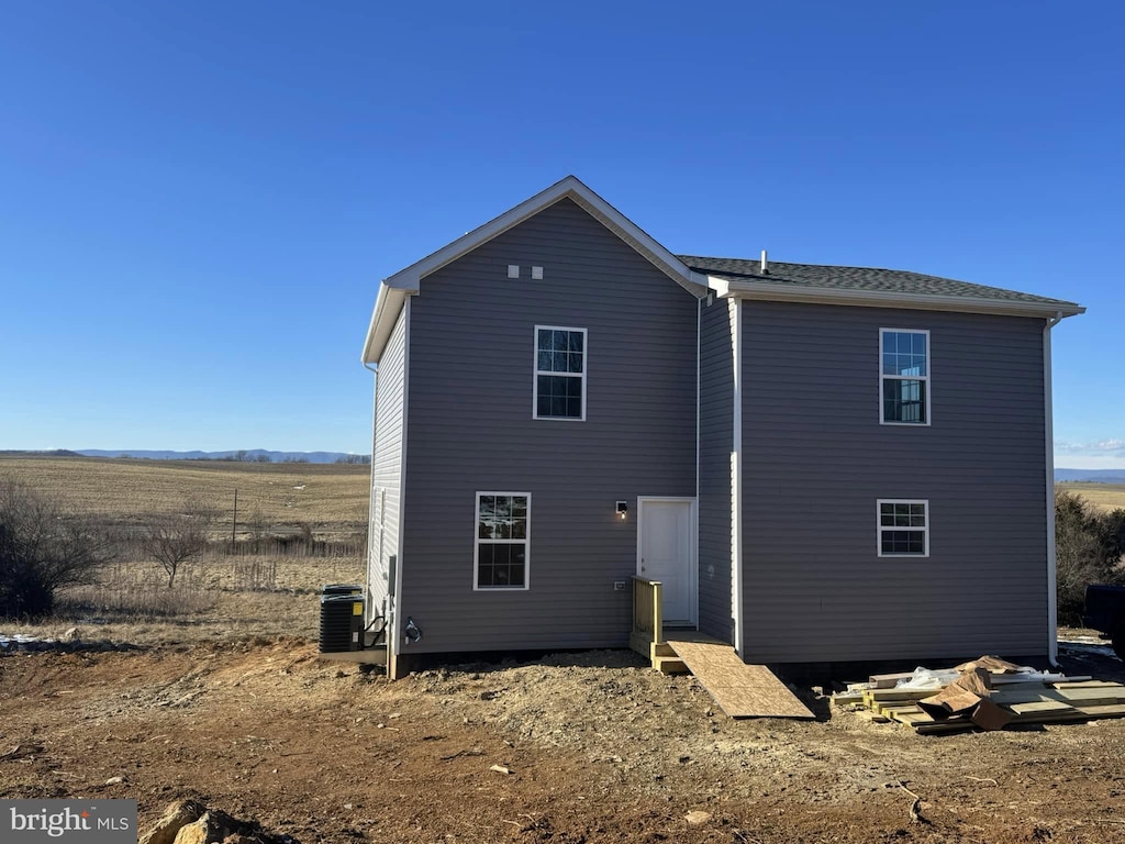 back of property featuring a rural view and central air condition unit