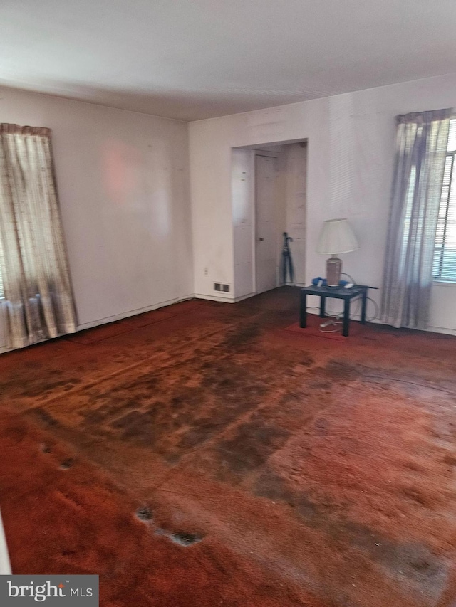 unfurnished room featuring dark carpet