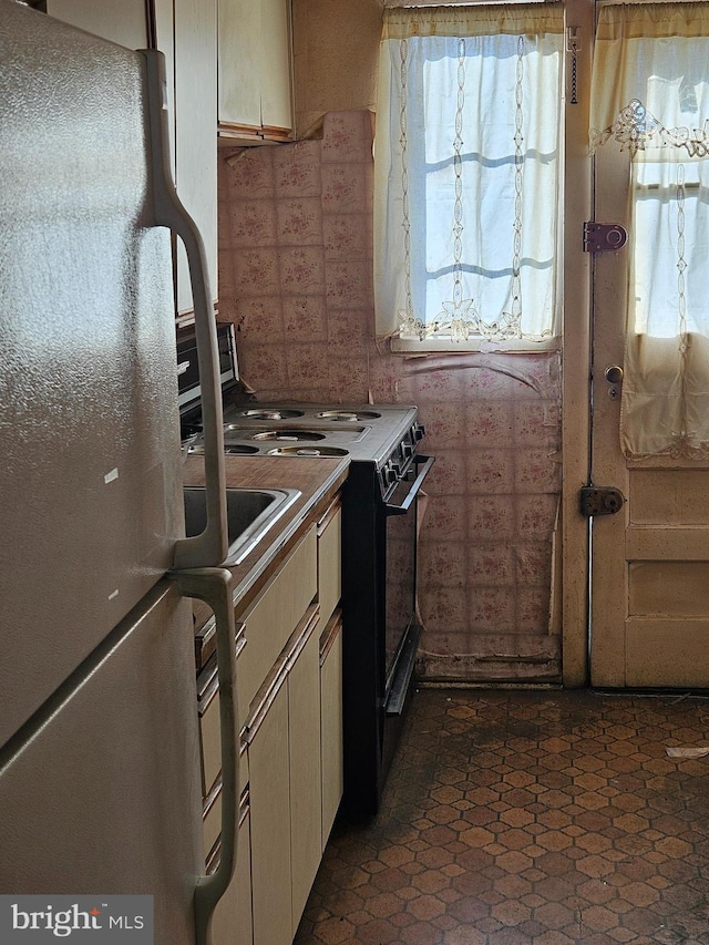 kitchen with fridge and black stove