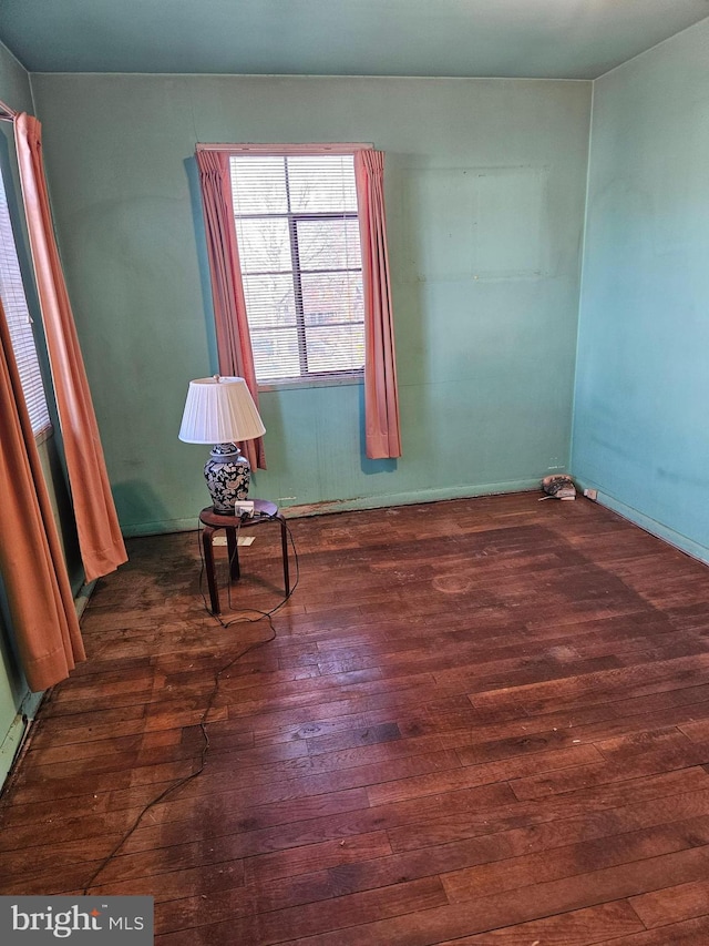 unfurnished room with dark hardwood / wood-style flooring