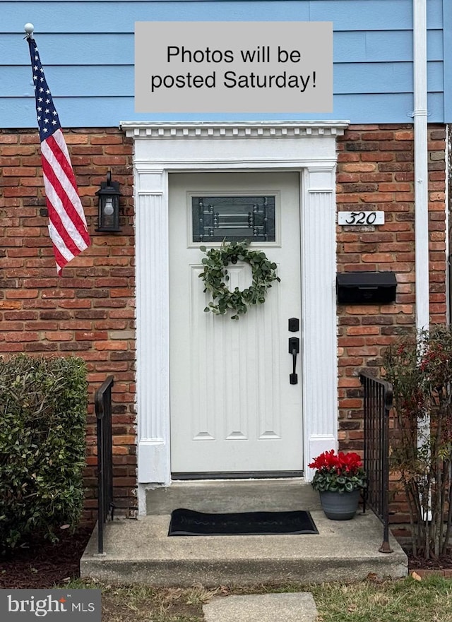 view of exterior entry featuring brick siding