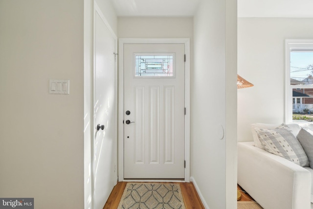 entryway with baseboards and wood finished floors