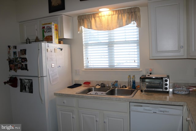 kitchen with sink, white appliances, and white cabinets