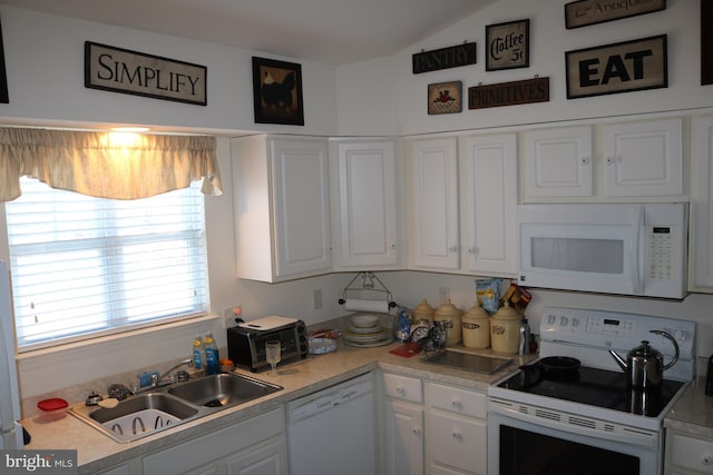 kitchen with white appliances, lofted ceiling, sink, and white cabinets