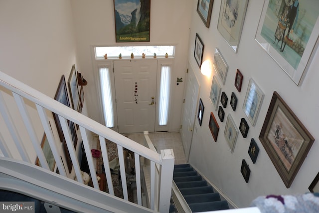 foyer entrance with tile patterned flooring and a high ceiling