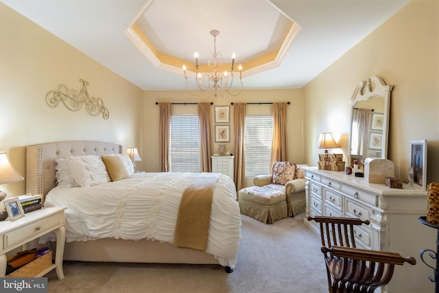 bedroom featuring a chandelier, light colored carpet, and a raised ceiling