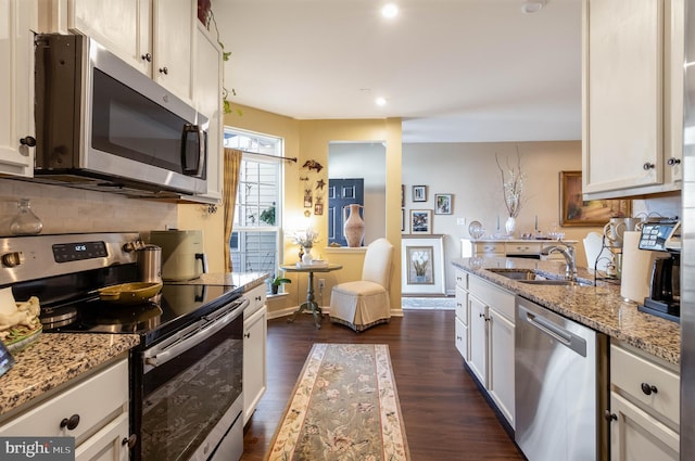 kitchen featuring white cabinetry, appliances with stainless steel finishes, sink, and light stone counters