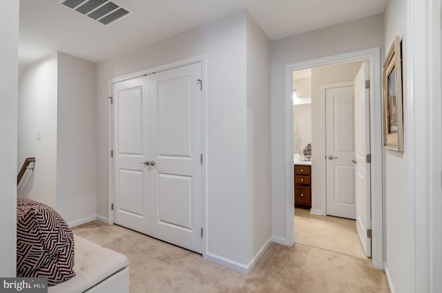 corridor featuring light colored carpet