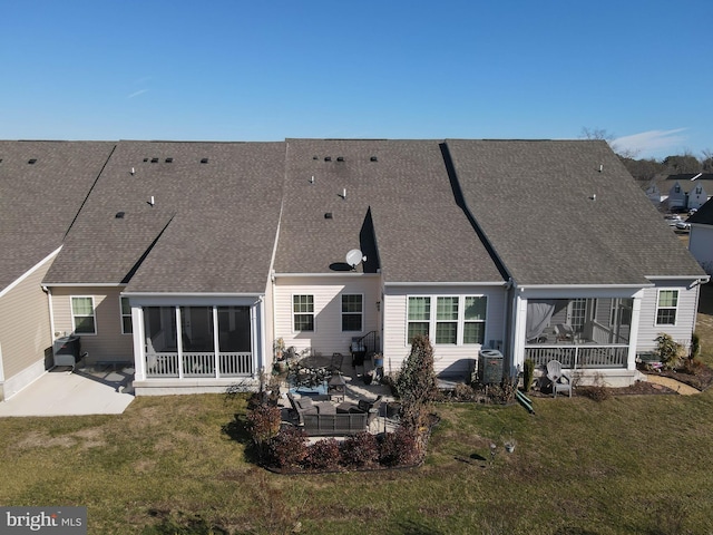 back of property featuring a patio, a yard, and a sunroom