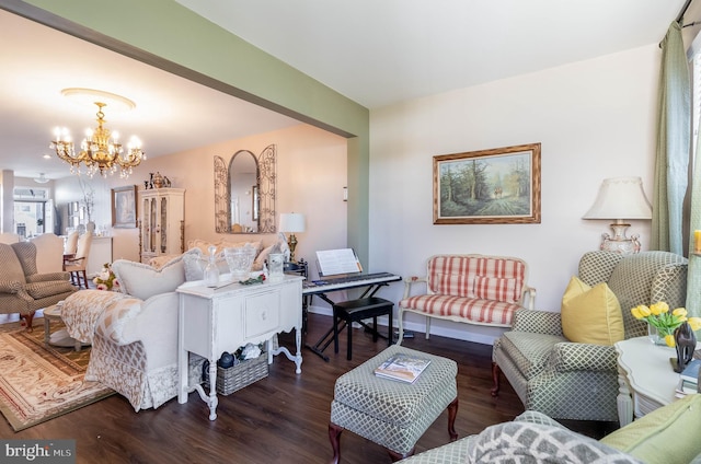 living room featuring an inviting chandelier and dark wood-type flooring