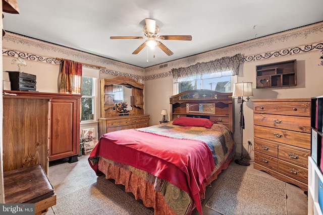 carpeted bedroom with multiple windows and ceiling fan