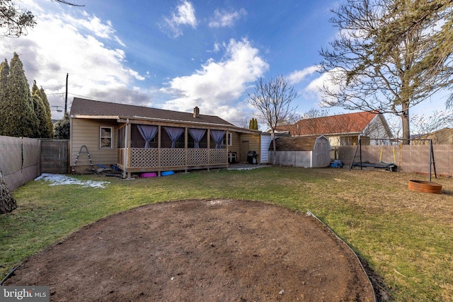 back of house with a shed and a lawn