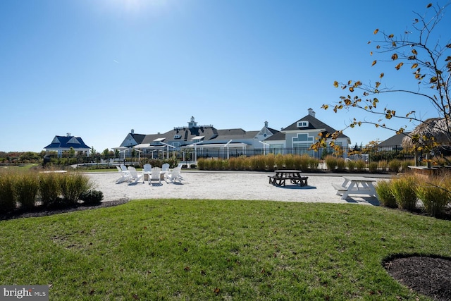 view of property's community with a lawn and volleyball court