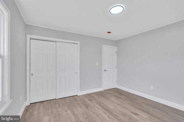 unfurnished bedroom featuring light hardwood / wood-style flooring and a closet