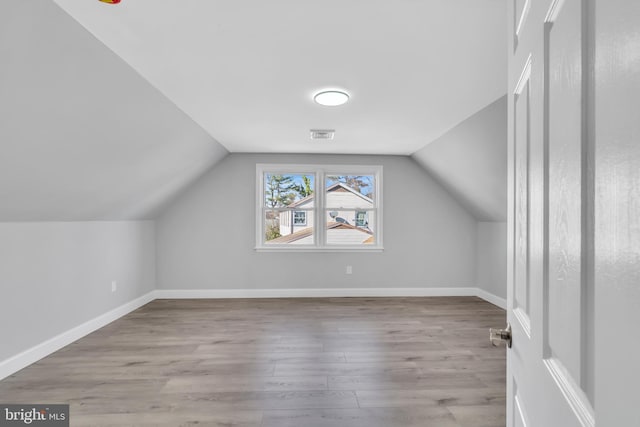 bonus room featuring vaulted ceiling and light hardwood / wood-style floors