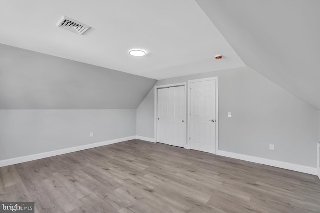 bonus room featuring lofted ceiling and light hardwood / wood-style floors