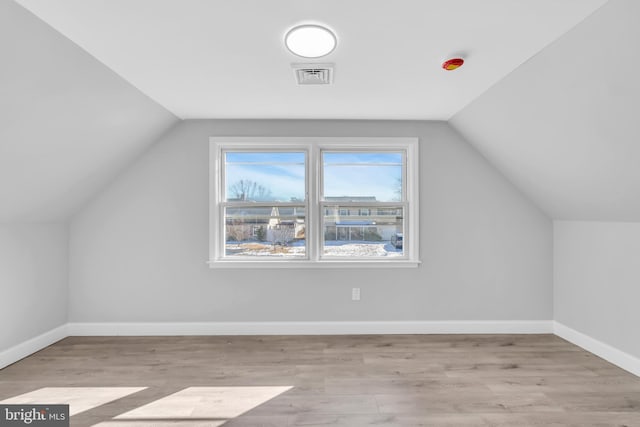 bonus room featuring vaulted ceiling and light wood-type flooring