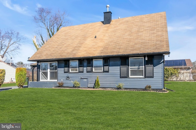 rear view of house featuring a yard