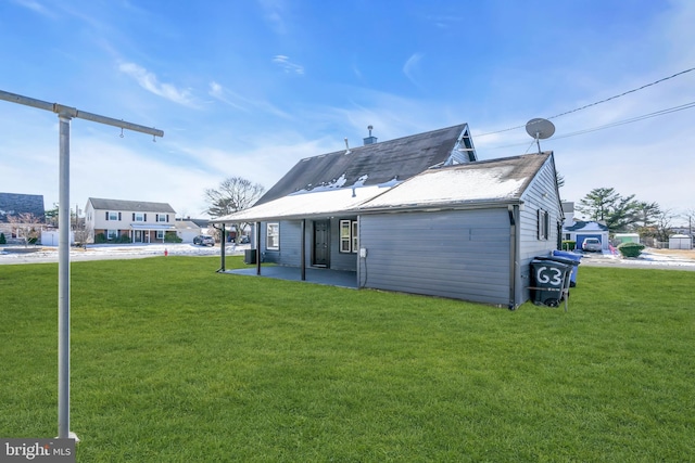 rear view of property featuring a yard and a patio