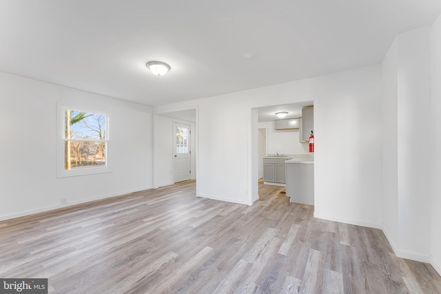 spare room featuring light wood finished floors and baseboards
