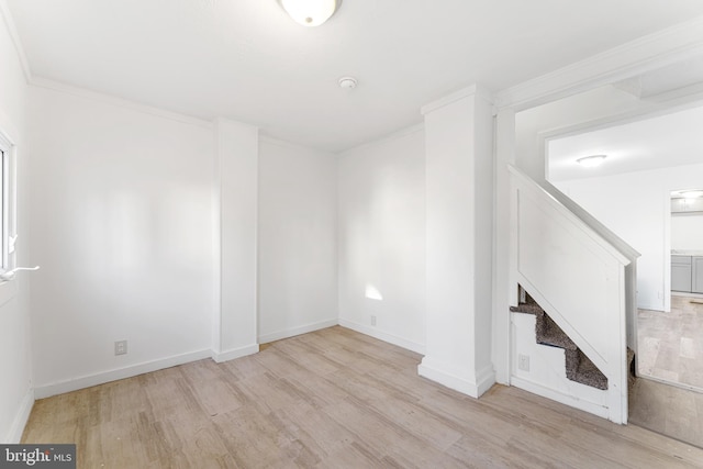 unfurnished living room featuring baseboards, wood finished floors, stairs, and crown molding