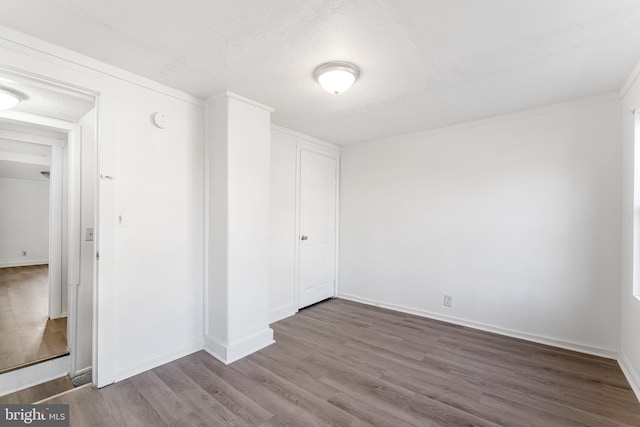 interior space featuring baseboards, a textured ceiling, and wood finished floors