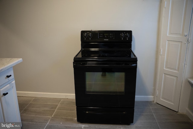 room details with electric range and white cabinets