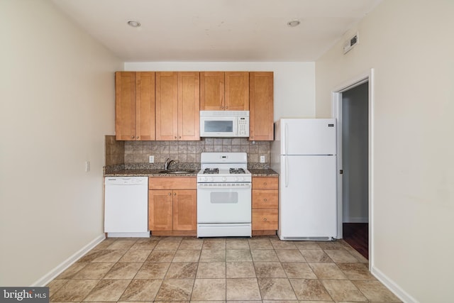 kitchen featuring sink, white appliances, dark stone counters, and backsplash