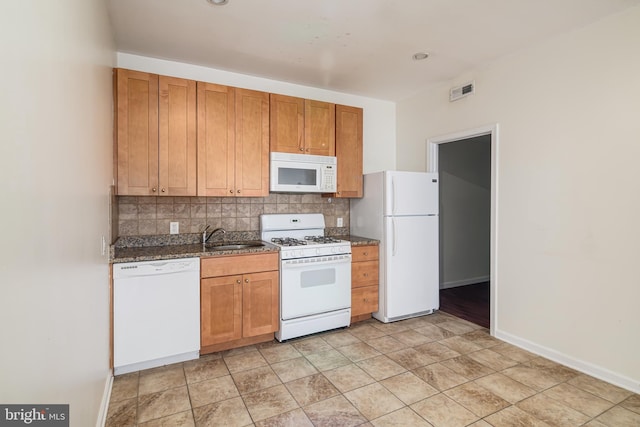 kitchen featuring tasteful backsplash, white appliances, sink, and light tile patterned floors