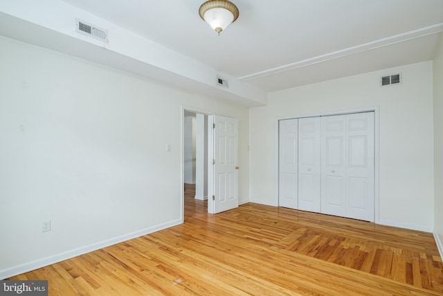 unfurnished bedroom featuring light wood-type flooring and a closet