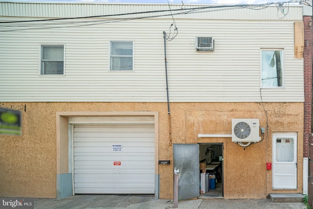 exterior space featuring a garage and ac unit