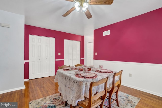 dining space with hardwood / wood-style flooring and ceiling fan