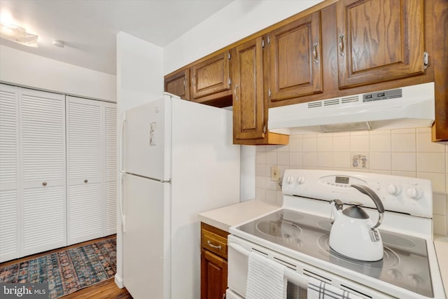 kitchen featuring white appliances and decorative backsplash