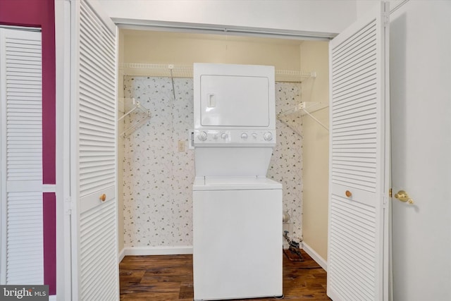 laundry area with stacked washing maching and dryer and dark hardwood / wood-style floors