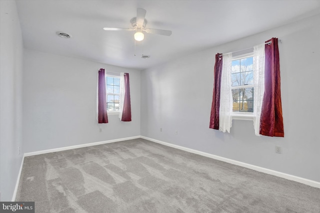 carpeted empty room featuring a wealth of natural light and ceiling fan