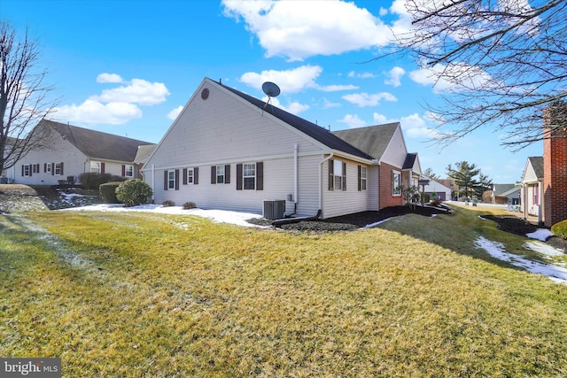 view of side of home with a lawn and central air condition unit