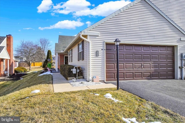 view of home's exterior with a garage and a lawn