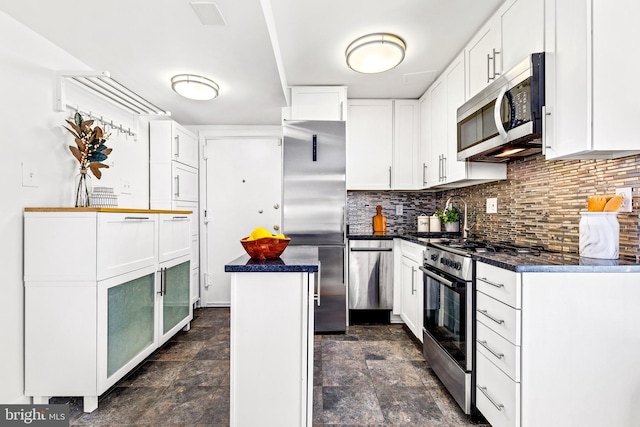 kitchen featuring decorative backsplash, a center island, white cabinets, and appliances with stainless steel finishes