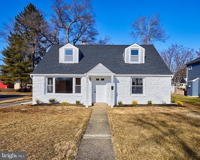 cape cod house featuring a front lawn