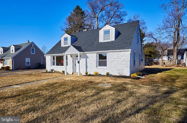 cape cod house with a front yard