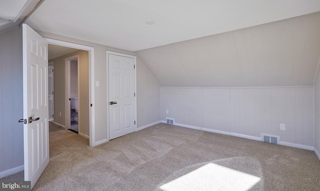 bonus room with light colored carpet and lofted ceiling