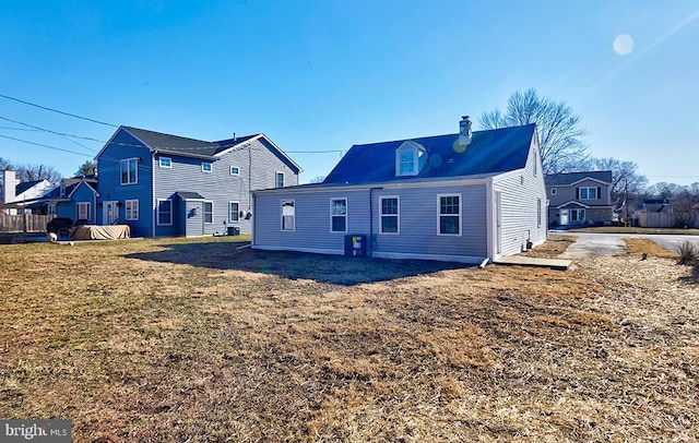 rear view of house featuring a yard