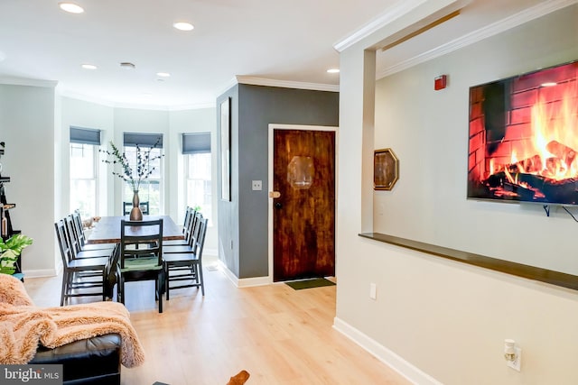 dining room with crown molding and light hardwood / wood-style flooring