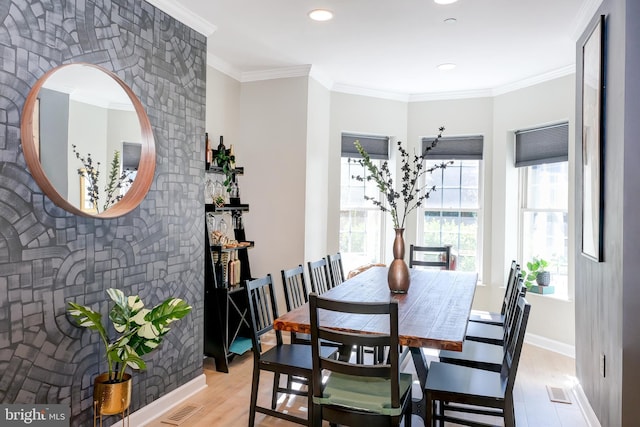 dining space featuring crown molding and light hardwood / wood-style floors