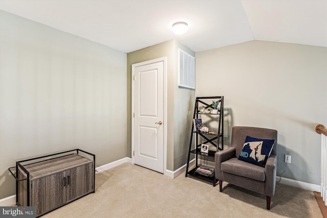 living area featuring lofted ceiling and light carpet